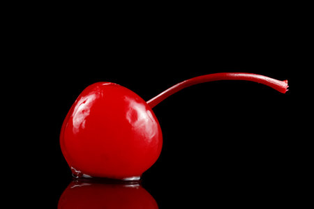 Cocktail cherry with stalk on black. red cocktail cherryの写真素材