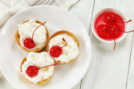 Baskets of pastries with cherry and cream. Cake basket with meringue and cherriesの写真素材