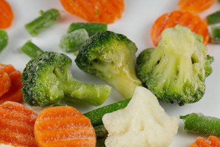 Frozen vegetables close-up on a white background. Mixed frozen vegetables backgroundの写真素材