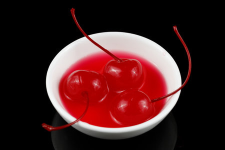 Cocktail cherry in a white saucer cup.の写真素材