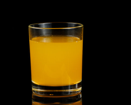 Orange juice in a glass isolated on blackの写真素材
