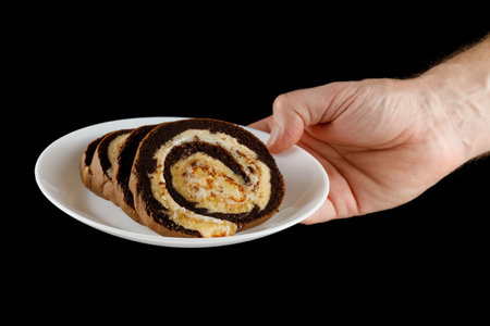 Chocolate Swiss Roll on a plate in handの写真素材
