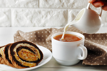 Sweet pastry roll. traditional breakfast. Chocolate Swiss Roll and coffee with milkの写真素材