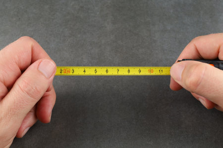 Self-retracting metal tape measure in hands. measuring instrumentsの写真素材