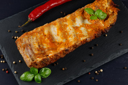 Baked ribs with basil and spices. Rustic vintage wooden table, in a pan of fried juicy pork ribs with meat, spicesの写真素材