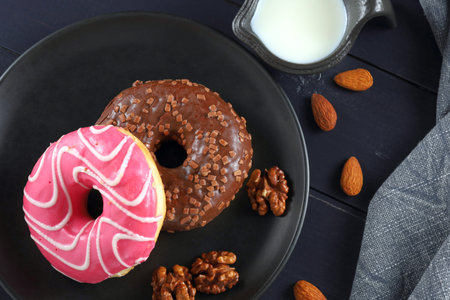 Donuts on a plate. Tasty and sweet breakfast. Close-up of colorful donuts on tableの写真素材
