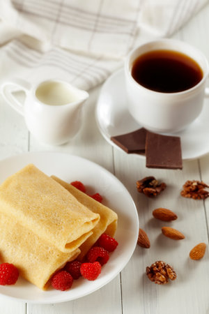 Pancakes with raspberries in coffee and milk. Sweet breakfast.の写真素材