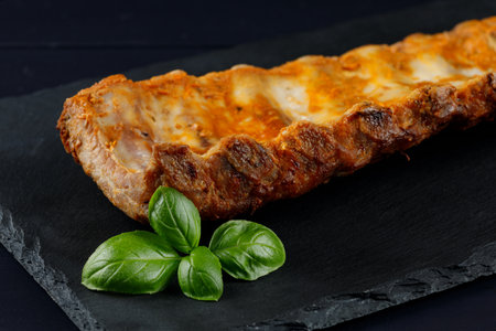 Baked ribs with basil and spices. Rustic vintage wooden table, in a pan of fried juicy pork ribs with meat, spicesの写真素材