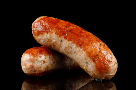 Two fried sausages on black.の写真素材