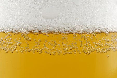 Light beer with foam close-up. Water drops on glass of beer. light beer backgroundの写真素材