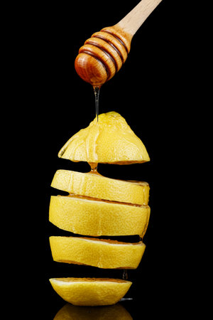A cut lemon is poured with honey. Honey jar with lemonの写真素材