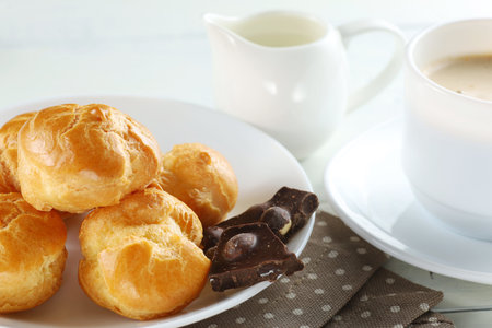 eclairs with chocolate, cappuccino and milk. Sweet breakfast.の写真素材
