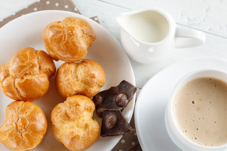 eclairs with chocolate, cappuccino and milk. Sweet breakfast.の写真素材