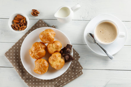 eclairs with chocolate, cappuccino and milk. Sweet breakfast.の写真素材