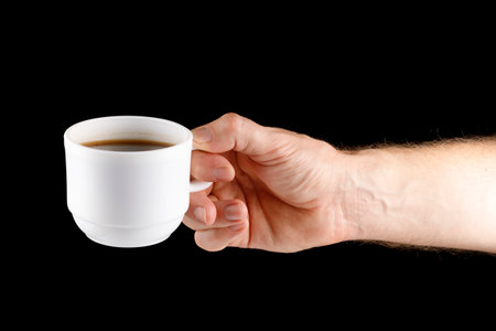 Hand holding white cup of coffee isolateの写真素材