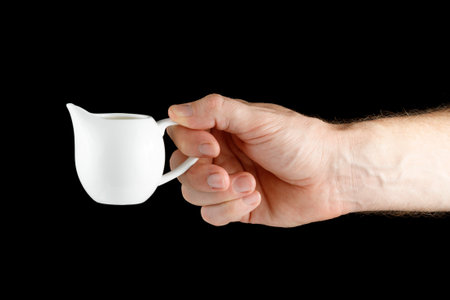 A white man's hand holds a Creamer isolateの写真素材