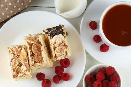 Tiramisu, raspberries and coffee with milk. Classic tiramisu dessert with raspberries, cup of coffee and milkの写真素材