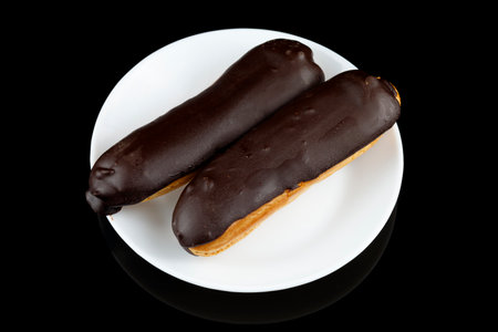 Chocolate eclairs in a white plate close-up.の写真素材