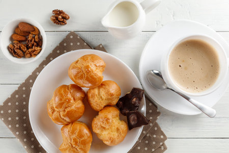 eclairs with chocolate, cappuccino and milk. Sweet breakfast.の写真素材
