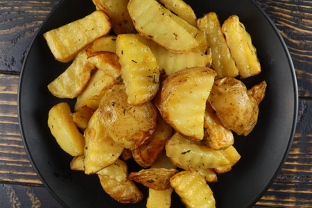Fried potatoes in a black plate.の写真素材