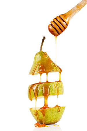 Pear with honey on white isolate. Delicious fruit dessert. Honey flows down the pear.の写真素材