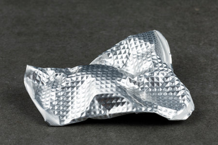 Crumpled aluminum foil on concrete close-up.の写真素材