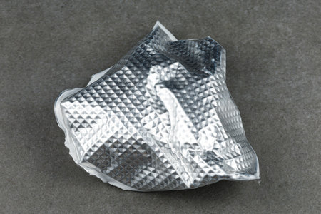 Crumpled aluminum foil on concrete close-up.の写真素材