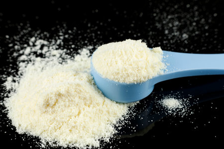 Baby food and a blue spoon. Yellow powder for baby food.の写真素材