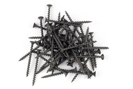 Screws on white. Pile of black tapping screws isolated on a white background.の写真素材