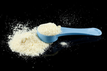 Baby food and a blue spoon. Yellow powder for baby food.の写真素材