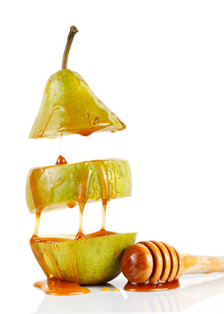 Pear with honey on white isolate. Delicious fruit dessert. Honey flows down the pear.の写真素材