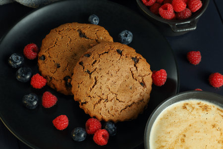 Oatmeal cookies with cappuccino and berriesの写真素材