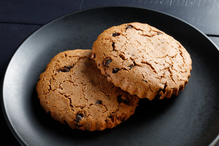 Oatmeal cookies with berries on dark plateの写真素材