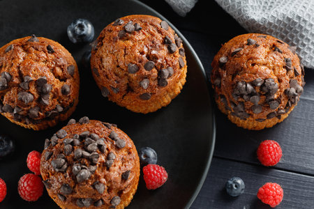 Chocolate muffin with berries. Appetizing cupcakes on a dark background.の写真素材