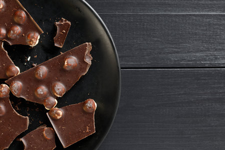 Pieces of chocolate in a black plate. place for text cope spaceの写真素材