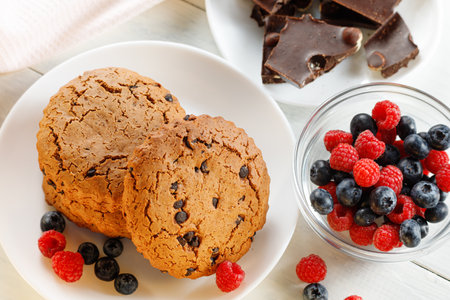 Oatmeal cookies with chocolate and berries on white. Oatmeal cookies with chocolateの写真素材