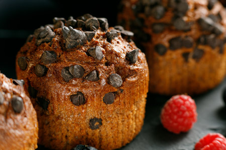 Chocolate muffin with berries. Appetizing cupcakes on a dark background.の写真素材