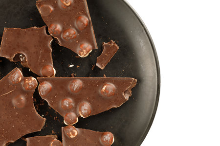 Pieces of chocolate with nuts in a black plate. place for text cope spaceの写真素材