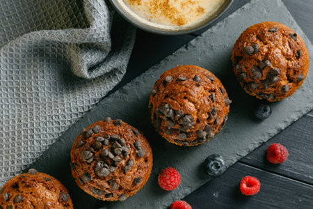 Muffins chocolate cupcakes with cappuccino and berriesの写真素材