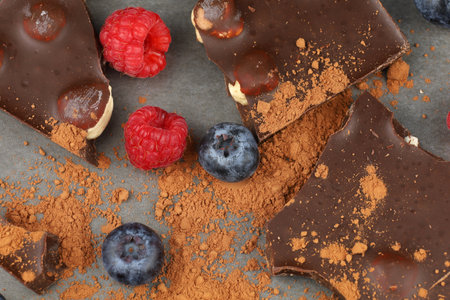 Chocolate with nuts, cocoa and berries. milk chocolate pieces with fruits and nutsの写真素材