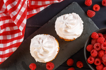 Raspberry cupcakes with berries on a white background. Appetizing cakes with cream.の写真素材
