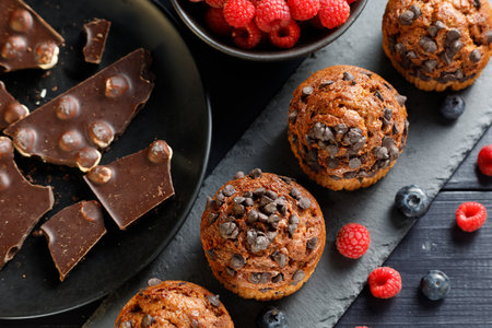 Chocolate muffins with berries and chocolate. Fresh baked chocolate muffins with blueberriesの写真素材