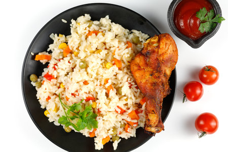 Fried chicken and rice with vegetables in a plate. Tasty and hearty foodの写真素材