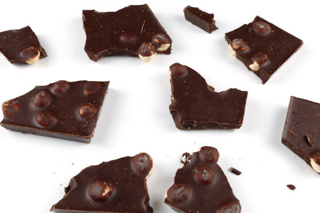 Pieces of chocolate with nuts on whiteの写真素材