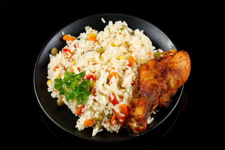 Fried chicken and rice with vegetables in a plate. Tasty and hearty foodの写真素材