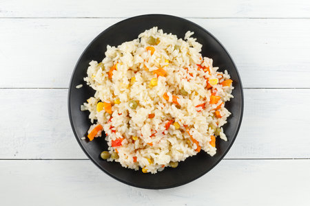 Rice with vegetables in a plate on the table.の写真素材