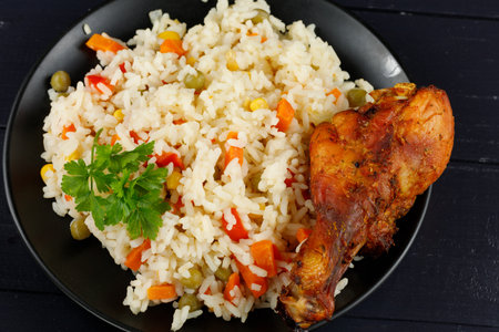 Fried chicken and rice with vegetables in a plate. Tasty and hearty foodの写真素材