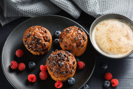 Muffins chocolate cupcakes with cappuccino and berriesの写真素材