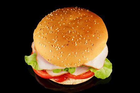 burger with lettuce, tomato, cheese and cutlet top view. burger isolated on black backgroundの写真素材