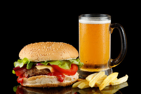 Burger with beer and french fries. Burger with beer isolate on black.の写真素材